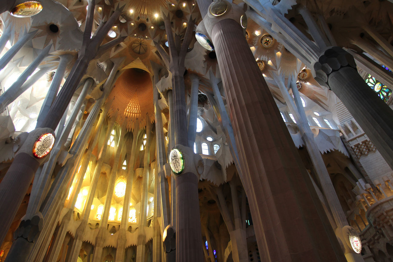 LOW ANGLE VIEW OF ILLUMINATED CHANDELIER HANGING AMIDST BUILDINGS