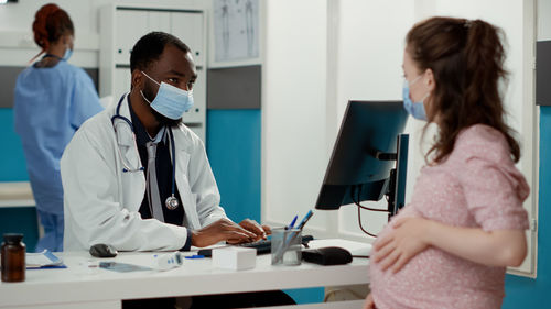 Male doctor examining patient at clinic