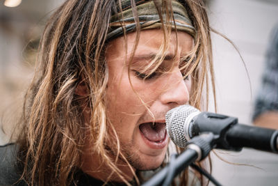 Face of a young rocker singing in the street