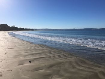 Scenic view of beach against clear blue sky