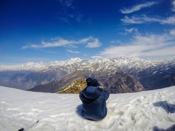 Rear view of snow covered mountain against sky