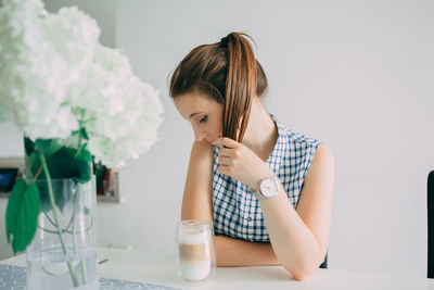 Rear view of woman sitting on table