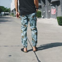 Low section of man walking on road