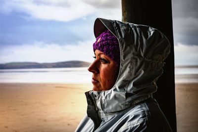 Close-up of person with umbrella on beach against sky