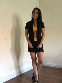 Portrait of smiling young woman standing against wall at home