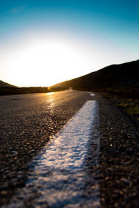 Surface level of road against sky during sunset