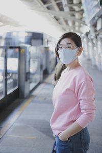 Portrait of woman standing on railroad station platform