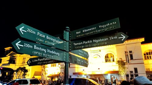 Illuminated information sign on street in city at night