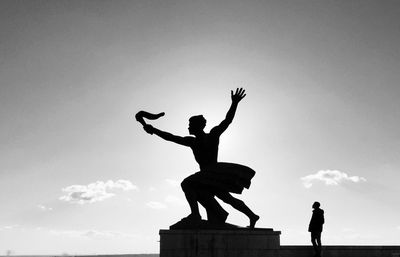 A man looking up on statue symbolizing liberty and freedom, silhouette 