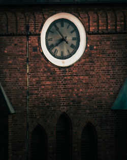 Low angle view of clock on brick wall