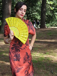 Young woman smiling while standing on tree trunk