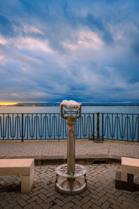 Sunset over the sea with cloudy sky with panoramic binoculars in the foreground