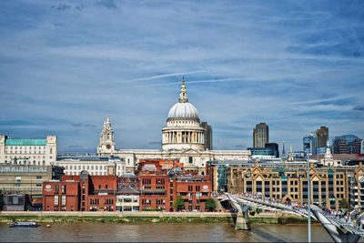 View of buildings in city against cloudy sky