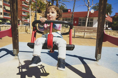 Full length of boy swinging at playground