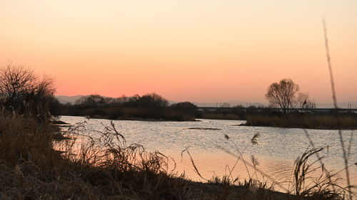 Scenic view of lake against romantic sky at sunset