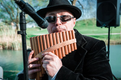 Portrait of man wearing sunglasses holding camera