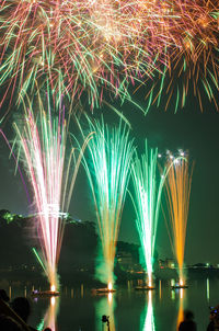 Illuminated firework display in sky at night