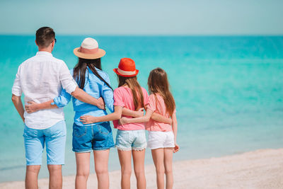 Rear view of women standing at beach