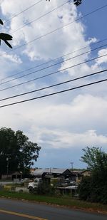 Low angle view of trees and building against sky