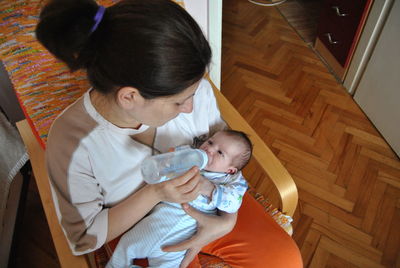 Close-up of mother feeding baby at home