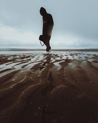 Full length of man on beach against sky