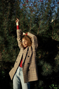 Young woman dancing against plants