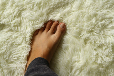 Low section of person relaxing on bed