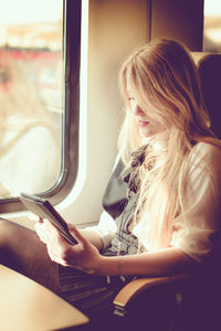 Woman looking at camera while sitting in airplane