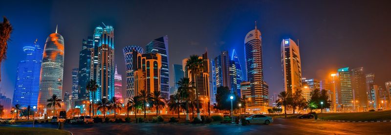 Panoramic view of illuminated buildings against sky at night