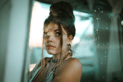 Portrait of woman looking through window