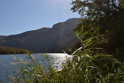 Scenic view of sea and mountains against sky