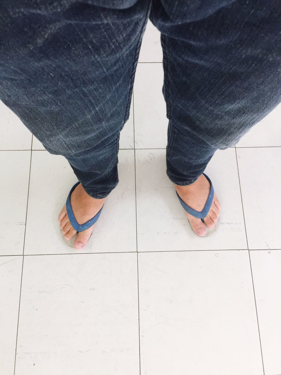 LOW SECTION OF MAN STANDING BY TILED FLOOR