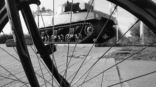 Close-up of bicycle hanging on metal against sky