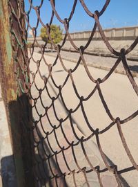 Close-up of chainlink fence against wall