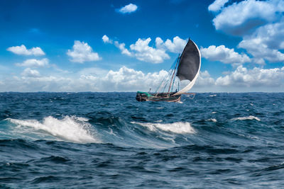 Man surfing in sea against sky