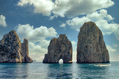 Rock formations in sea against sky