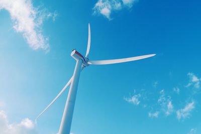 Low angle view of wind turbine against blue sky