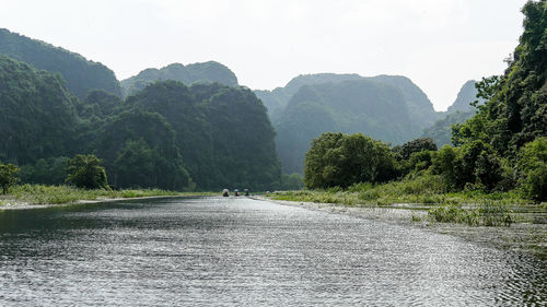 Road by trees against sky