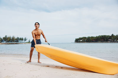 Rear view of shirtless man jumping in sea