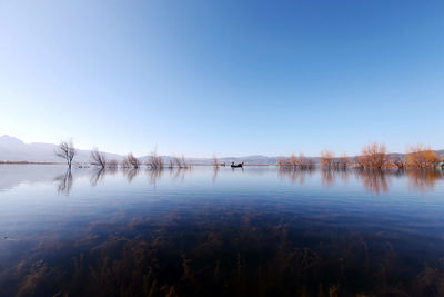 Calm lake against clear sky