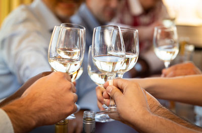 Midsection of man holding wine glass