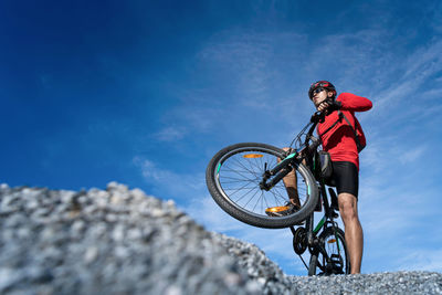 Low angle view of person riding bicycle against sky