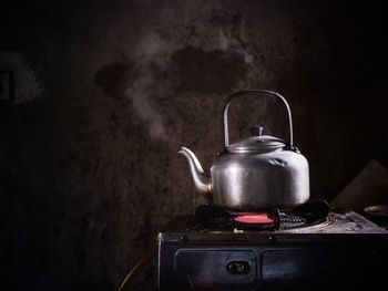 Kettle on burning stove in kitchen