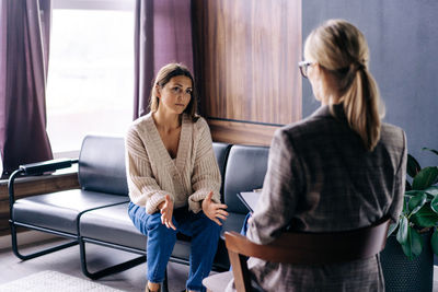 A young woman in a consultation with a professional psychologist talks about her problems. 