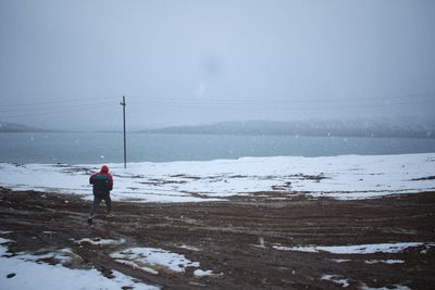 Rear view of man standing at beach