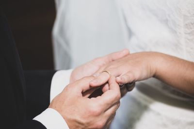 Midsection of couple exchanging wedding ring