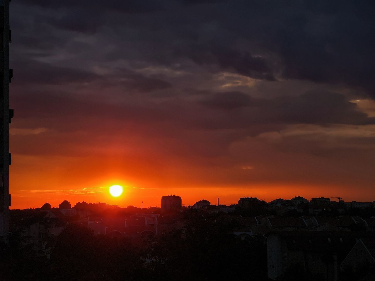 SILHOUETTE BUILDINGS AGAINST ORANGE SKY