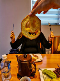 Midsection of person holding ice cream on table