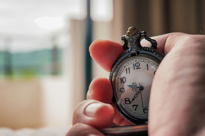 Cropped hand holding clock