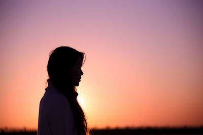 Silhouette woman standing against sky during sunset